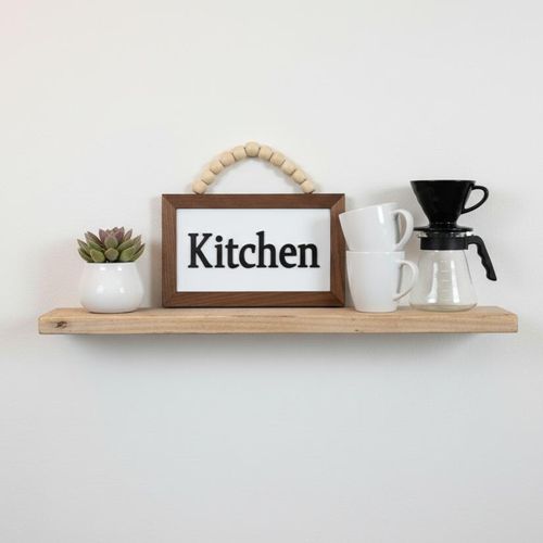 A distinctive wooden wall decoration featuring the word "Kitchen" in relief. This three-dimensional decorative plaque, measuring 20x12 cm, is made of premium 8mm thick Spanish MDF wood, adding beauty and elegance to any corner of the kitchen.