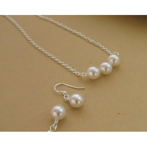 A sophisticated jewelry set featuring a necklace and matching earrings blending timeless simplicity with modern grace