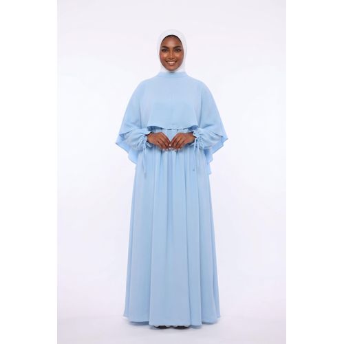 Women's loose-fitting dress with a detachable cape and long sleeves.