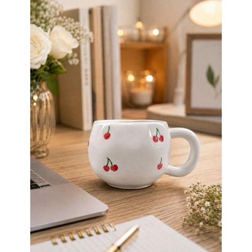 A white mug with a red cherry design, a stylish and cute coffee and tea cup for everyday use, perfect for gifts.