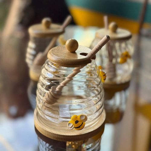 Honeycomb-shaped glass jar, with wooden lid, drip spoon and saucer, decorative bee design