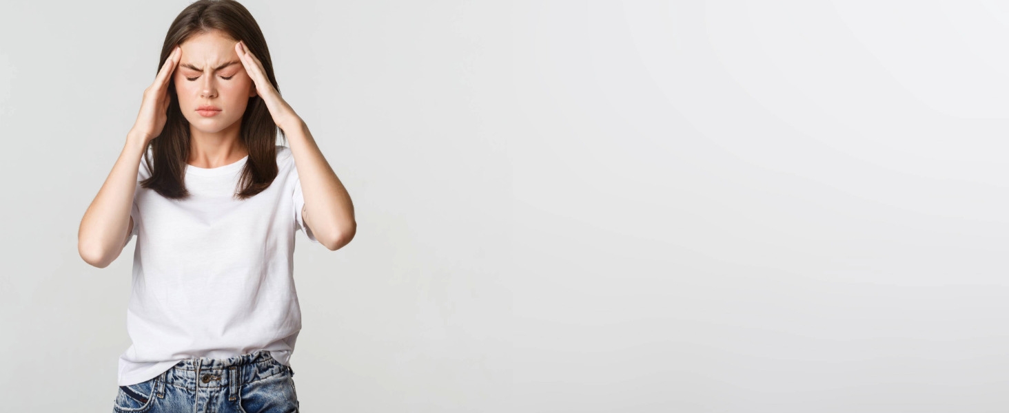 Camiseta blanca de manga corta usada por una persona con las manos levantadas sobre la cabeza, de pie sobre un fondo claro