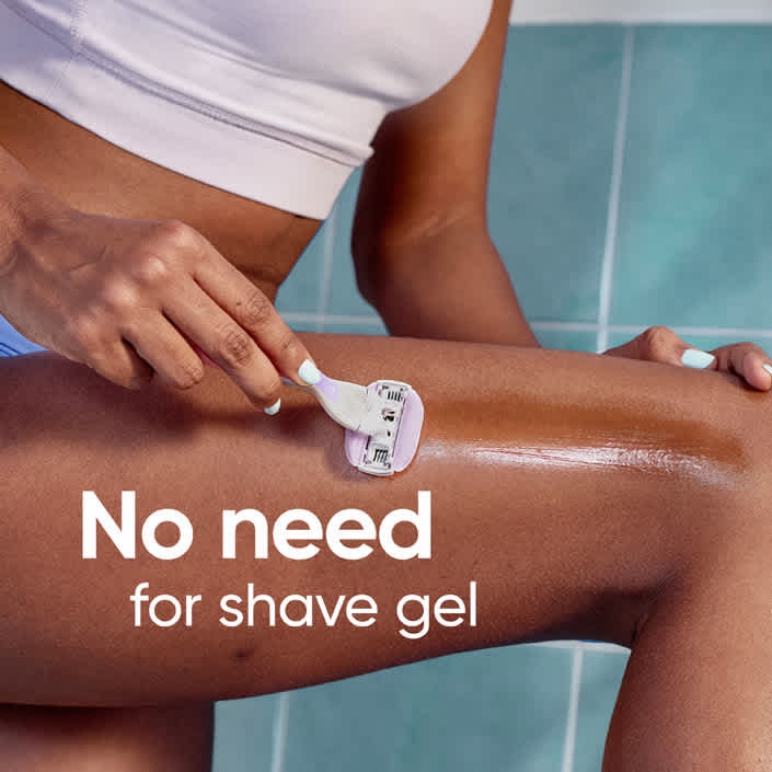 Lady shaving her leg in the bathroom, using Venus ComfortGlide Freesia Razor without the shaving gel.