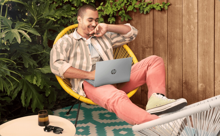 رجل يتصفح الويب ممسكًا بجهاز كمبيوتر محمول HP Pavilion Aero مقاس 13.3 بوصة فوق ساقيه