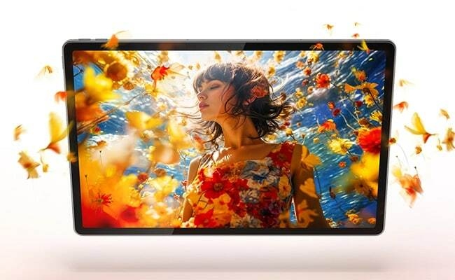 جهاز Lenovo Idea Tab Plus – منظر أمامي يعرض سيدة بفستان مزهر مع مؤثرات بصرية زهرية تبدو وكأنها تخرج من الشاشة، بوضع أفقي، باللون الرمادي القمري
