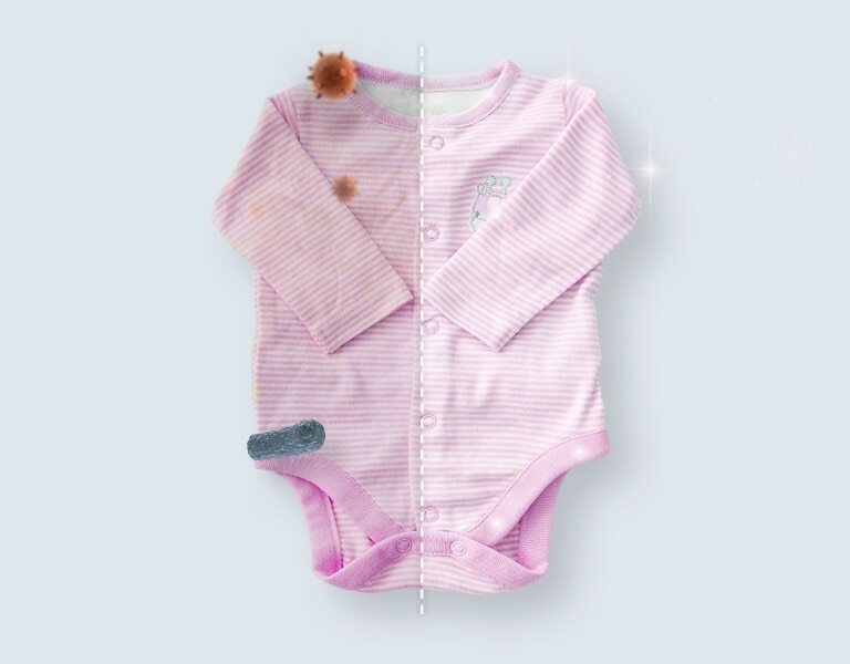 بدلة أطفال نصفها الأيسر متسخ ببقع داكنة، بينما نصفها الأيمن نظيف ومشرق ويبدو كالجديد تحت الإضاءة.