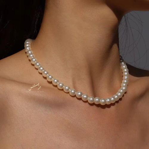 A stunning high-quality faux pearl choker that sits elegantly on the neckline, offering a royal look that blends modern style with vintage charm