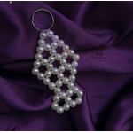 Bracelets ميدالية مفاتيح بتصميم أنيق ومميز. مصنوعة من خرز لؤلؤ أبيض لامع. الخرز مرتب بشكل هندسي متناسق. التصميم يوضح شكل فانوس بشكل واضح ومميز.