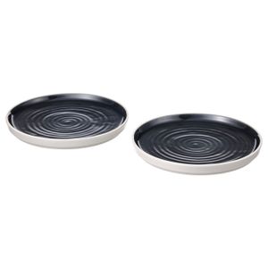 Side plate Two black, round, ceramic dishes with white rims and swirling patterns, positioned side by side.