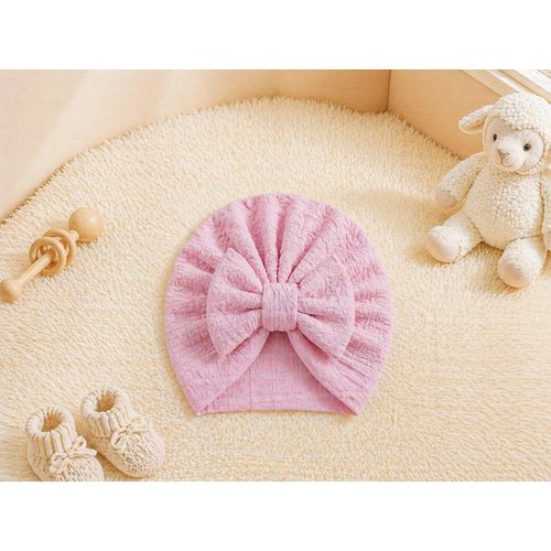 An elegant bow-adorned turban hat for infants a practical, flexible, and soft baby turban a ready-to-wear headpiece perfect for newborns and baby girls. It is an ultra-soft and stretchy baby headband.